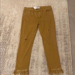 Light brown pants with fringe at bottom of legs